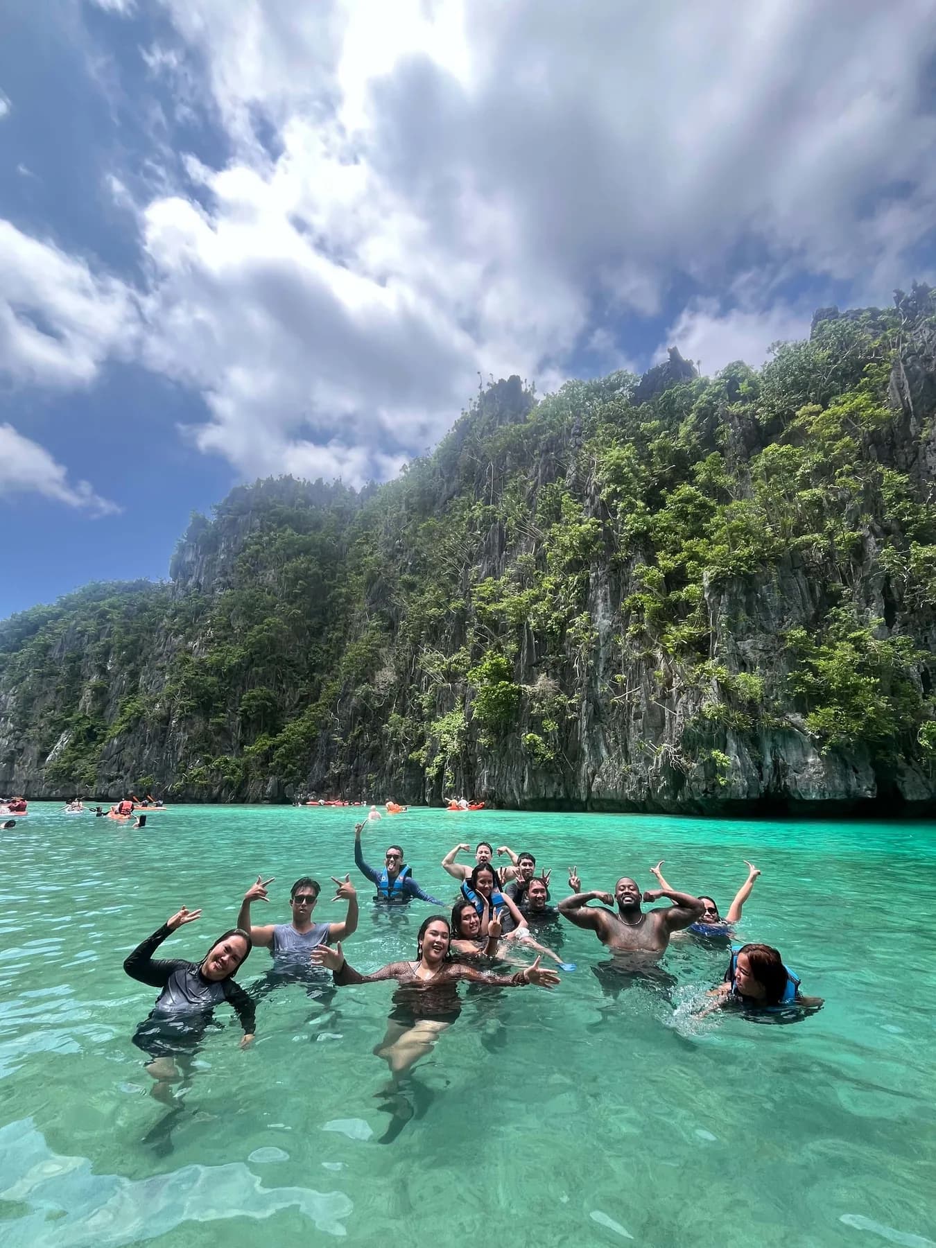 The MyThorneAI team swimming in turquoise water beneath limestone cliffs